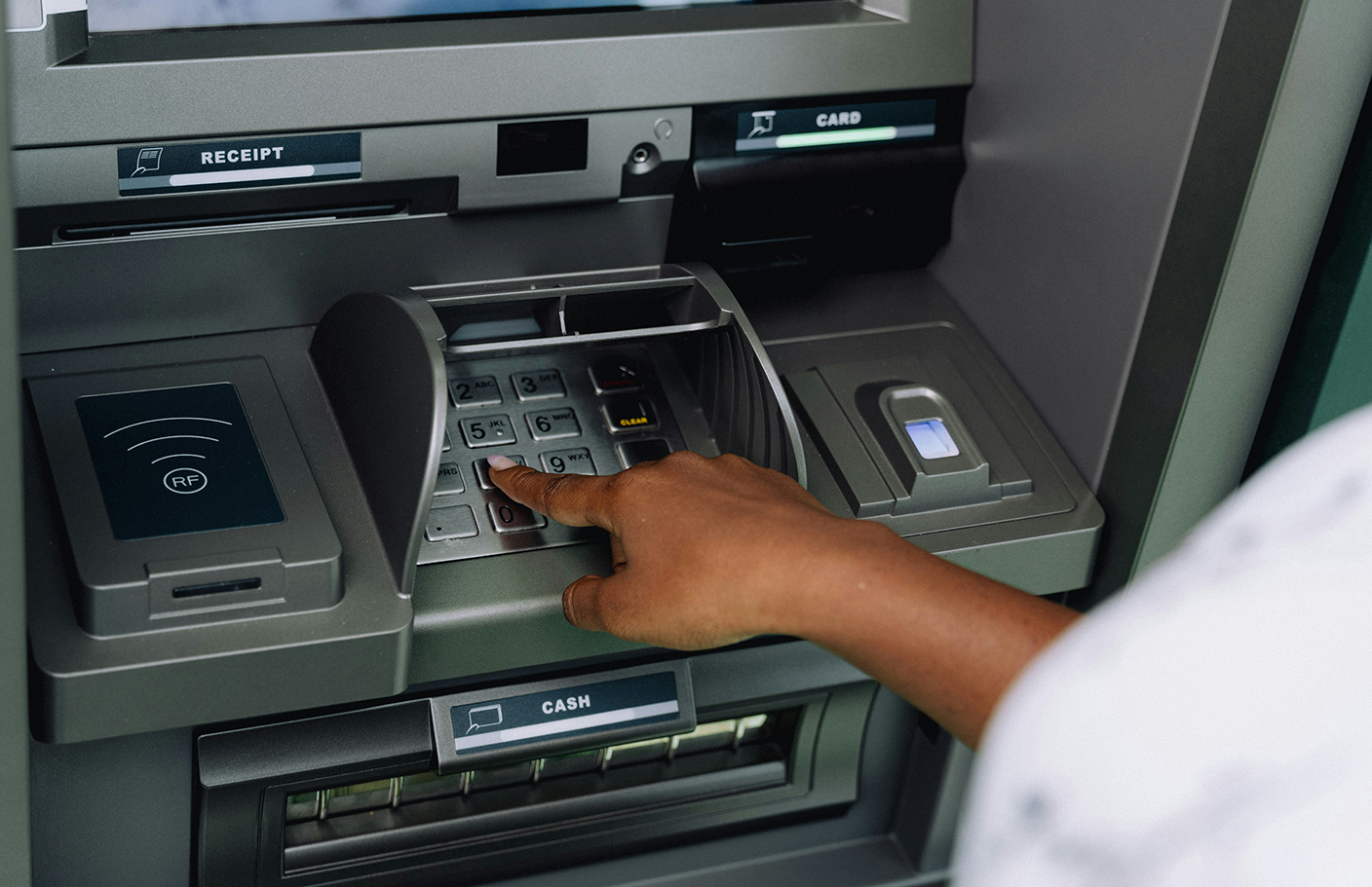 Person entering their pin at the ATM.