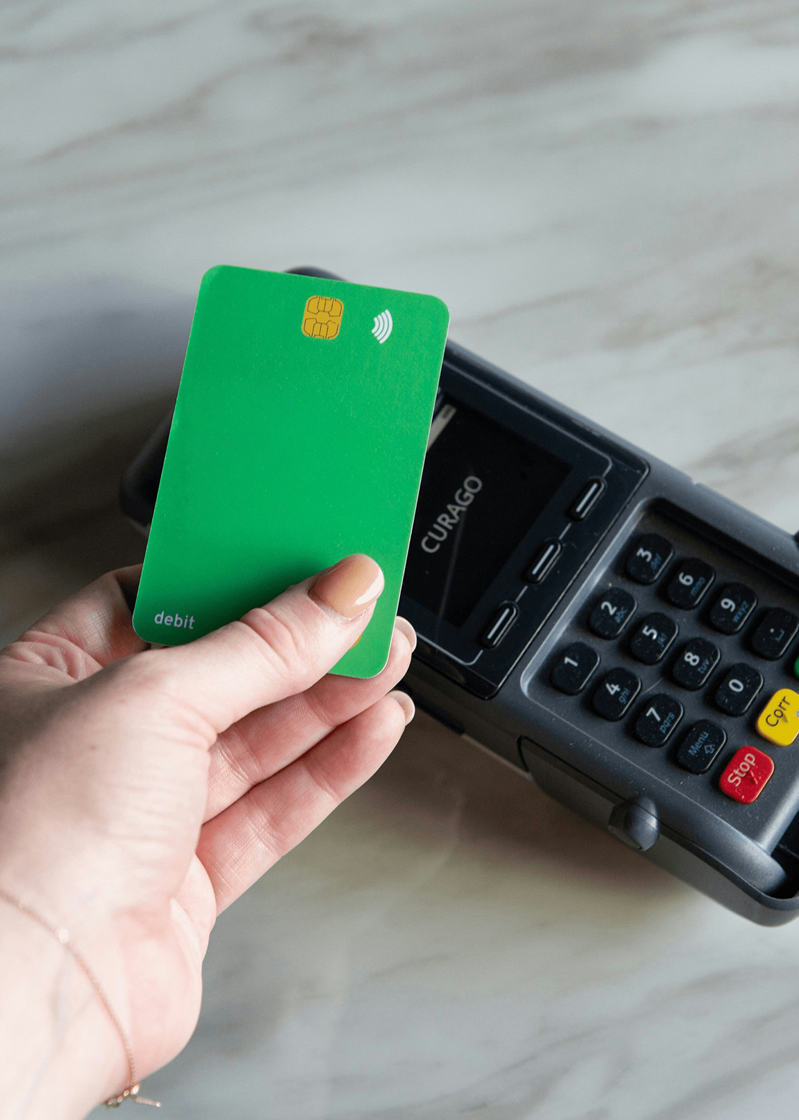Person using their debit card at a point-of-sale.